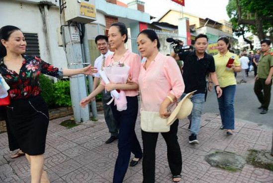 Bước chân ra khỏi tòa, cô hoa hậu vui vẻ tươi cười và được mọi người chào đón. Ảnh: SKĐS.