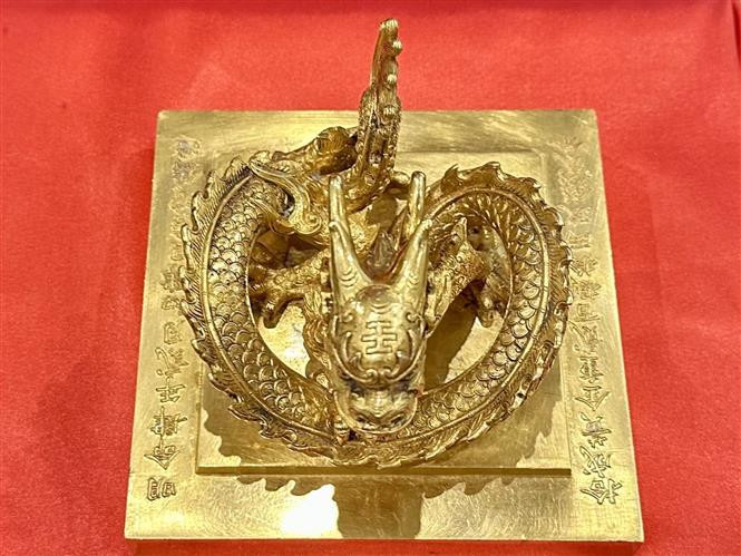 Mặt trên của ấn vàng khắc hai dòng chữ có nội dung: "Minh Mạng tứ niên nhị nguyệt sơ tứ nhật cát thời chú tạo" (Được làm vào ngày 4/2, năm thứ 4 đời vua Minh Mạng, tức ngày 4/2/1823) và "Thập thành hoàng kim trọng nhị bách bát thập lạng cửu tiền nhị phân" (Làm bằng vàng, nặng 280 lạng, 9 chỉ, 2 phân, khoảng 10,7 kg). Đế ấn in dòng chữ "Hoàng đế chi bảo" (Báu vật của hoàng đế). Ảnh: TTXVN.