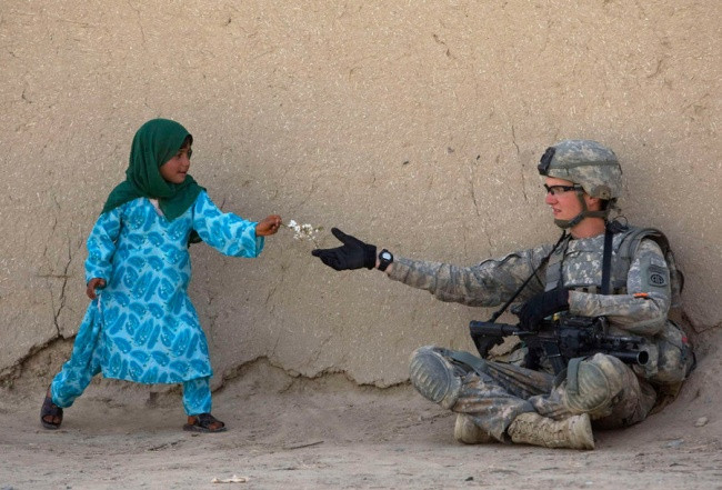 Người lính Mỹ nhận hoa từ một bé gái Afghanistan trong khi tuần tra ở thung lũng Arghandab của Afghanistan. Ảnh: Reuters.