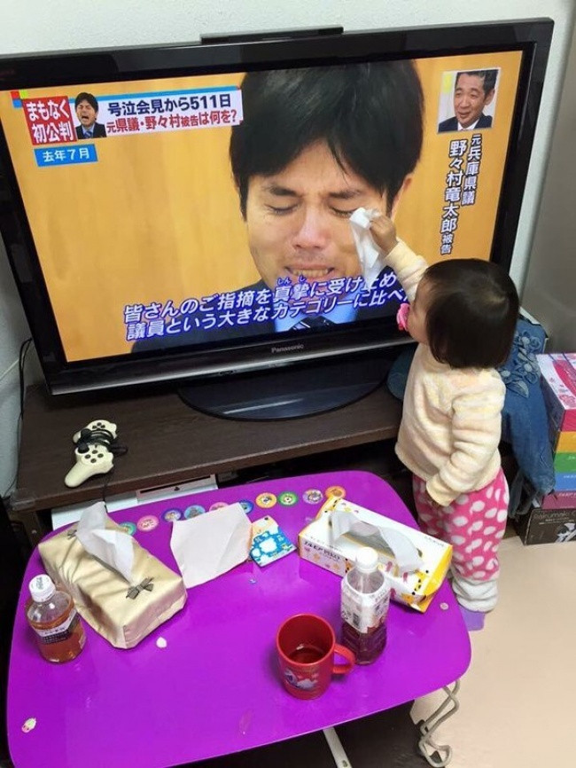  Đứa trẻ người Nhật này đang lau nước mắt cho một chính khách đang khóc trên màn hình TV. Ảnh: BS.
