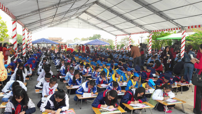 Các em học sinh chăm chú viết chữ đẹp trong lễ hội khai bút.