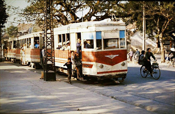 Một chuyến tàu điện chật kín hành khách. Khi tàu chưa chạy, một số trẻ em tò mò chạy lên xe điện xem phương tiện giao thông này như thế nào.