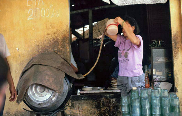 Chủ quán rót bia từ bom bia lớn cho khách.
