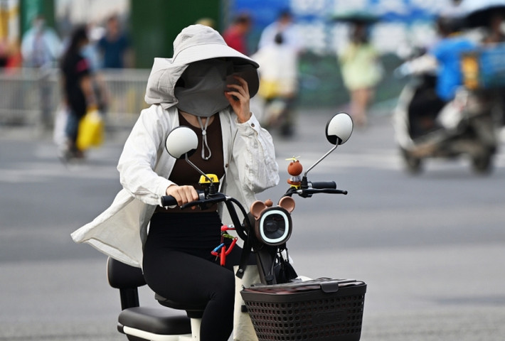Mức nhiệt cao đã được ghi nhận ở Trung Quốc và các quốc gia châu Á, trong đó có cả Việt Nam. Các chuyên gia thời tiết cảnh báo sẽ còn nhiều đợt nắng nóng hơn nữa. Trong hình là người phụ nữ Trung Quốc bịt kín khi ra đường vì nắng nóng ngày 30/5. Ảnh: VCG.