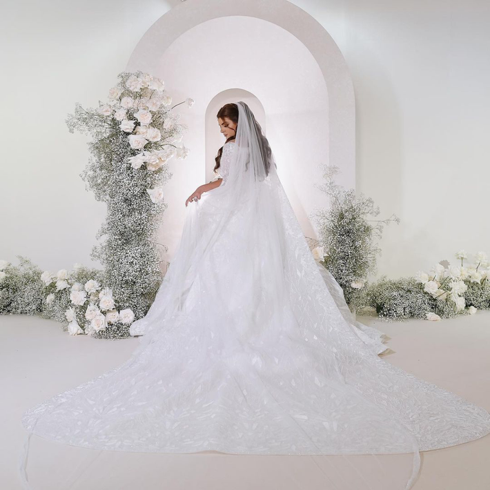 Công chúa Sheikha để tóc dài bồng bềnh, đội khăn voan thêu, trang điểm mắt khói đặc trưng và môi màu nude tự nhiên.