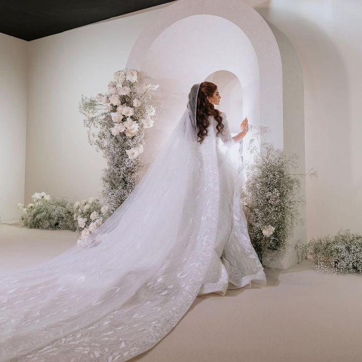 Cô dâu diện váy cưới thêu tay do nhà thiết kế Dubai Ezra Couture chế tác. Điểm nhấn là bộ trang sức kim cương tinh xảo và đồng hồ kim cương của thương hiệu Chopard.