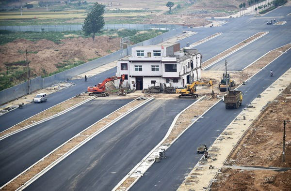 Ngôi nhà ba tầng với lá cờ Trung Quốc nằm giữa con đường mới xây ở tỉnh Hà Nam. Ảnh: Reuters.