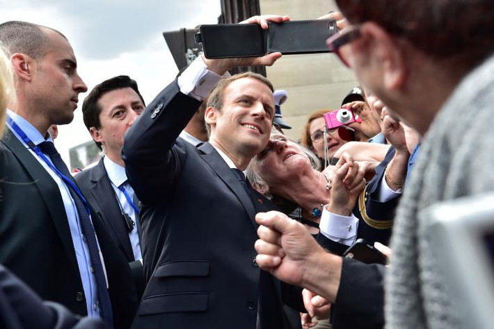 Tổng thống Pháp Emmanuel Macron chụp ảnh với một phụ nữ khi ông gặp đám đông sau cuộc diễu hành.