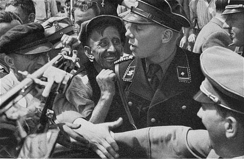 Một sĩ quan SS cố gắng bắt tay Adolf Hitler khi trùm phát xít đi qua khu vực đám đông. Rất nhiều người muốn được bắt tay Hitler. Ảnh chụp năm 1935.