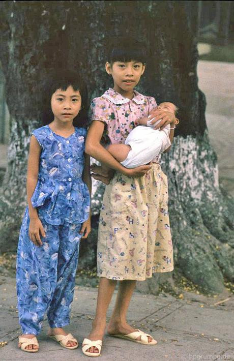 Người chị bế và ru em ngủ.