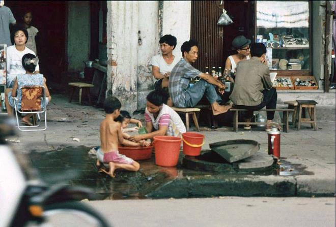 Hình ảnh gần gũi người mẹ tắm cho con nhỏ.
