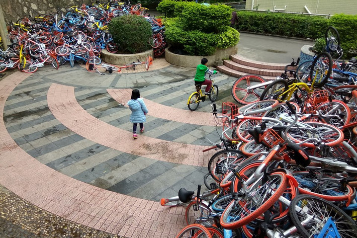 Hai em nhỏ chơi đùa tại nghĩa trang xe đạp ở Thâm Quyến.