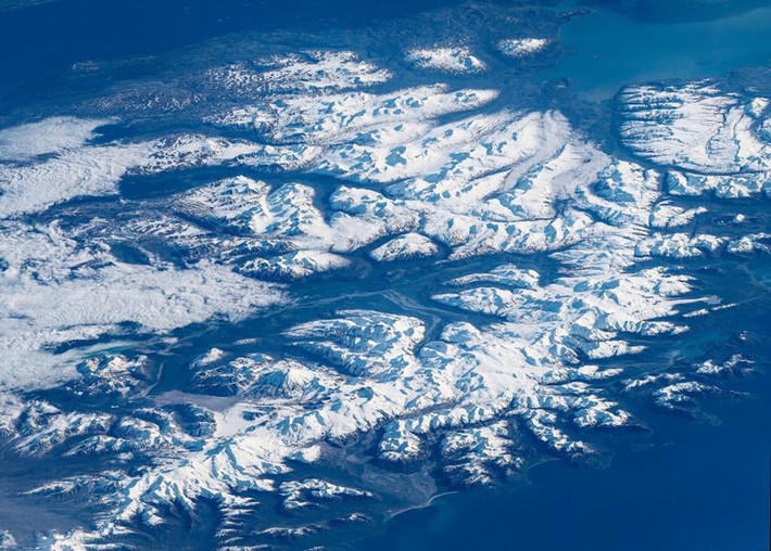 Vườn quốc gia Katmai: Katmai nằm trên phần Thái Bình Dương của bán đảo Alaska, đối diện đảo Kodiak trên eo biển Shelikof. Thuộc khu vực có khí hậu lạnh khắc nghiệt, công viên Katmai có nhiều ngọn núi với tuyết bao phủ quanh năm. Sắc xanh đậm và màu trắng tươi sáng nhảy múa phối hợp với nhau cùng ánh sáng và bóng tối trong Công viên quốc gia Katmai. Mây cuộn từ bên trái bức hình, nhưng nhìn từ bầu trời chúng xuất hiện và pha lẫn với những ngọn núi trắng tạo thành sự hòa quyện đặc biệt.