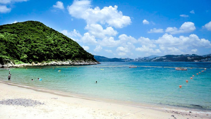 Hap Mun Wan: Hap Mun Wan là một trong những bãi biển xa xôi nhất của Hong Kong, đồng thời là điểm đến quen thuộc với cư dân bản địa nhưng vẫn còn xa lạ với du khách quốc tế. Nằm trên đảo Sharp, ngoài khơi bờ biển Sai Kung, ở phía đông bắc Hong Kong, du khách chỉ có thể đến bãi biển bằng kaito, một loại phà địa phương, từ bến tàu Sai Kung Town. Khi đặt chân đến bãi biển, du khách sẽ tìm thấy dải cát vàng rực rỡ, nước sạch cấp 1 và những ngọn đồi xanh ở hai bên. Ngoài ra, cũng trên đảo Sharp, những du khách còn có thể ghé thăm công viên quốc gia Kiu Tsui, là một phần của công viên địa chất toàn cầu ở Hong Kong. Ảnh: CNN.