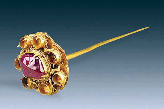 Một chiếc trâm cài tóc hình hoa sen 7 cánh được nạm viên ruby lớn ở giữa.