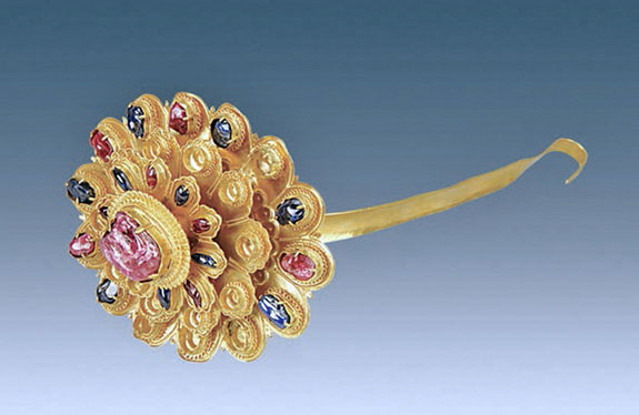 Trâm cài tóc vàng hình hoa cúc nổi bật với viên ruby lớn làm nhụy hoa và xung quanh là sapphire nhỏ và hồng ngọc trên cánh hoa.