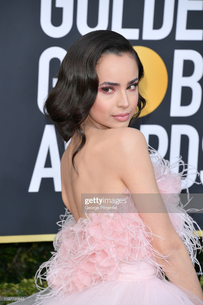 Sofia Carson chọn bộ đầm xếp tầng đính tua rua, phong cách trang điểm tông màu hồng đất nữ tính. Cô là nữ ca sĩ và diễn viên người Mỹ, xuất hiện lần đầu trên truyền hình với vai khách mời trong bộ phim hài của Disney Channel - Austin & Ally. Năm ngoái, cô góp mặt trong 2 dự án là Descendants 3 và Pretty Little Liars The Perfectionists.