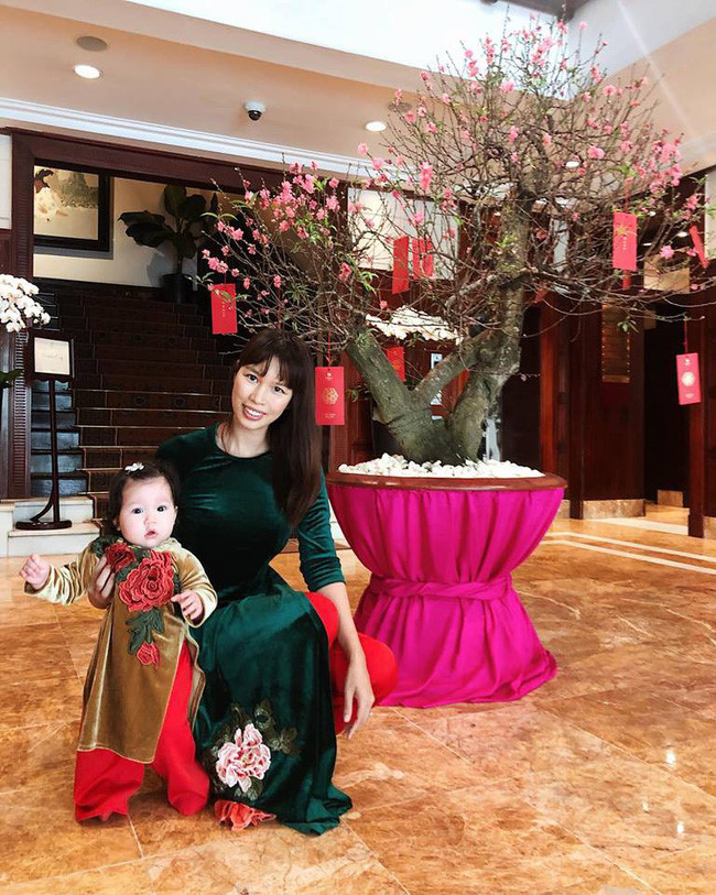 Người mẫu Hà Anh và con gái cùng diện áo dài thêu hình hoa cẩm chướng.