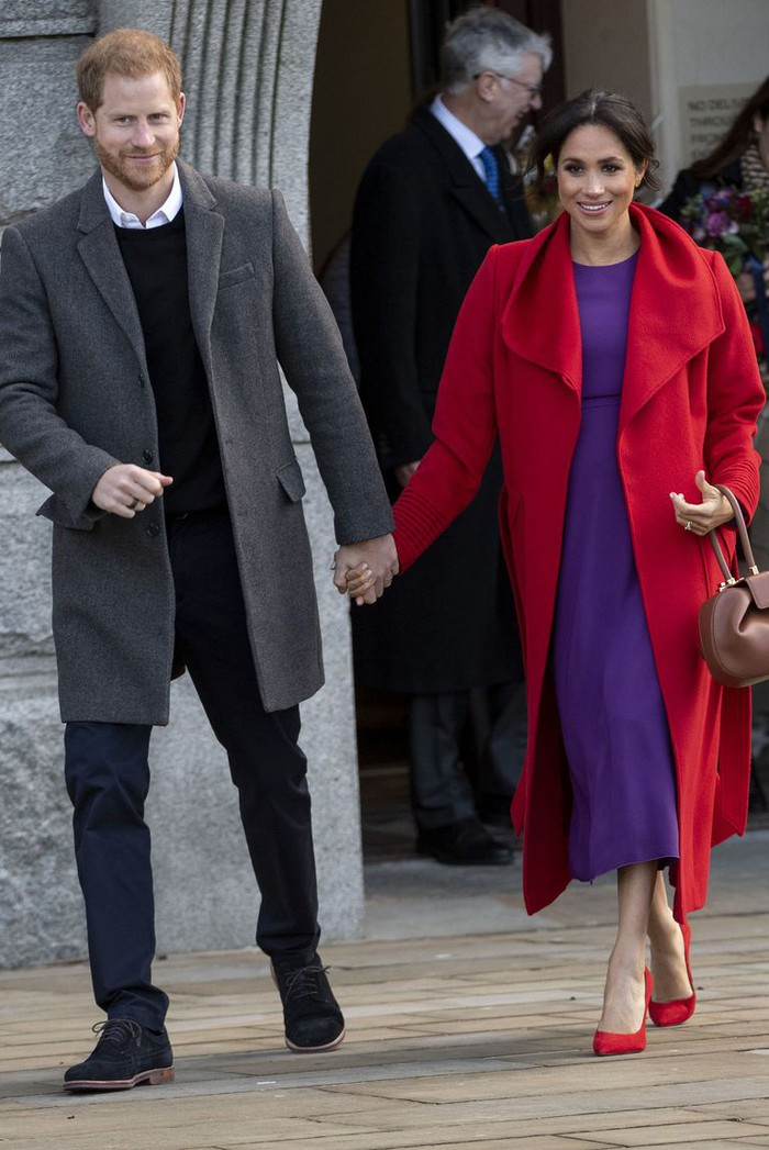 Chiếc váy tím được công nương Meghan phối với áo choàng đỏ và giày đỏ nổi bật.
