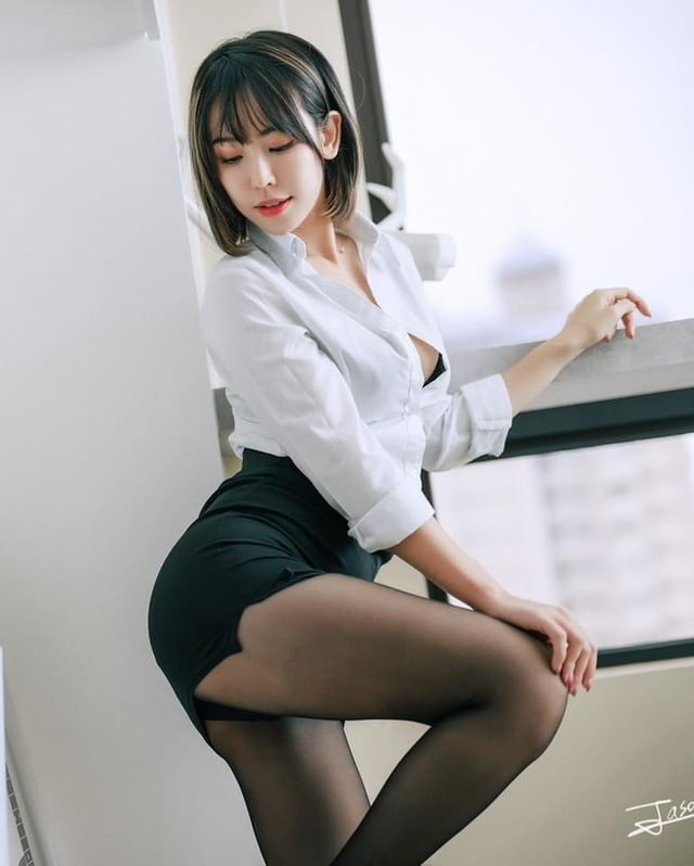 Trong những hình ảnh có thể thấy, Hi Hi diện một bộ đồ công sở cơ bản gồm áo sơ mi trắng và váy đen bó sát, mix cùng tất giấy màu đen, thoạt nhìn vô cùng bắt mắt.