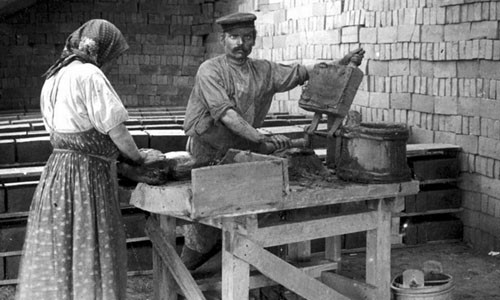 Người thợ miệt mài từng khâu đóng gạch để xây dựng nhà cửa.