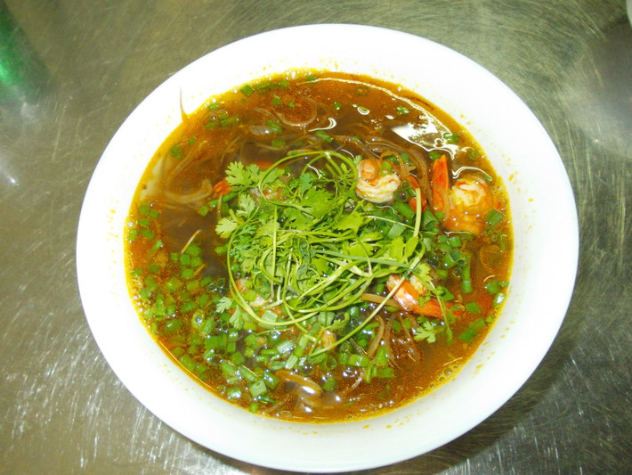 Cho nước đầu tôm vào nồi, lọc mẻ vào đun sôi. Thả cà chua đã thái vào nồi trước, rồi cho tôm vào, nêm nếm gia vị vừa ăn. Khi nước sôi lại, cho tiếp hoa chuối đã để ráo vào. Để nồi canh sôi lại thêm khoảng 5 phút (trong thời gian đó nhớ đảo hoa chuối trong nồi cho chín đều), cho hành và ngổ đã cắt khúc vào, tắt bếp.
