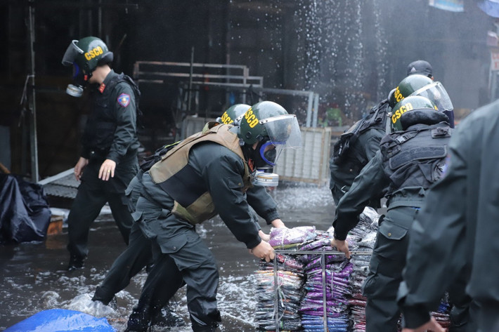 Lực lượng cảnh sát giúp người dân di chuyển hàng hóa. (Ảnh: Đàm Thanh)