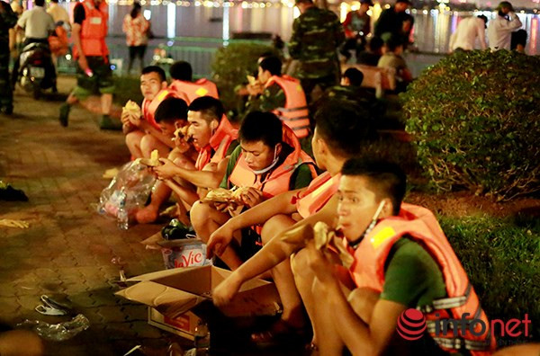 Việc thu gom cá chết được thực hiện liên tục không ngừng nghỉ. (Trong ảnh: Lực lượng thu gom cá Hồ Tây phải tranh thủ nghỉ ngơi và ăn giữa đêm khuya).