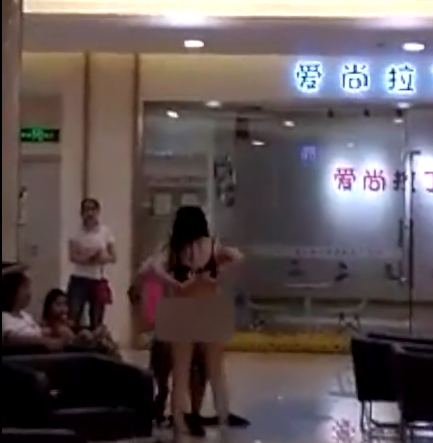 Trong đoạn video được đăng tải trêm Miaopai, người chồng cũ đã cố gắng lao vào ngăn cản cô vợ lột đồ nhưng bất thành.