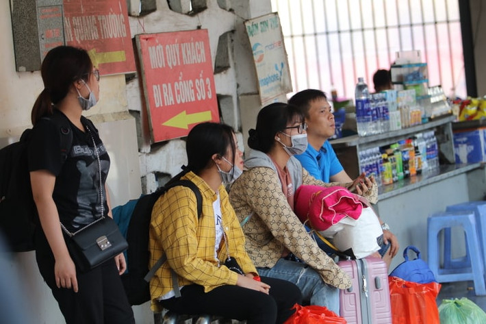 Nhiều người mệt mỏi sau chuyến đi dài, ngồi chờ xe bus để về nhà.