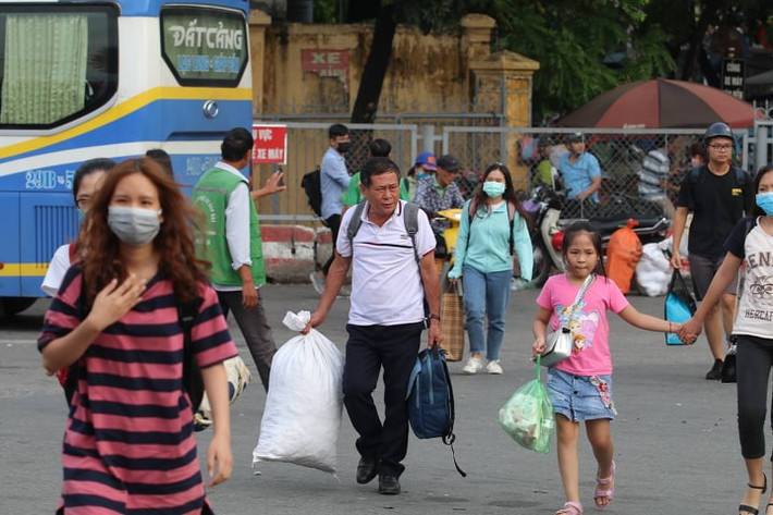 Trong bến xe, hành khách nào cũng tay xách nách mang hành lý.