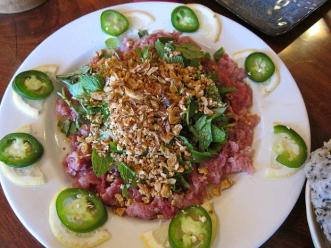 6. Món thịt bò tái chanh (Việt Nam): Món ăn này sử dụng thịt bò tươi, thái lát mỏng và ướp với nước cốt chanh để làm thành món thịt bò chín tái với axit từ chanh. Người Việt Nam ăn món này với ớt, hành khô và đậu phộng rang và một số rau thơm.