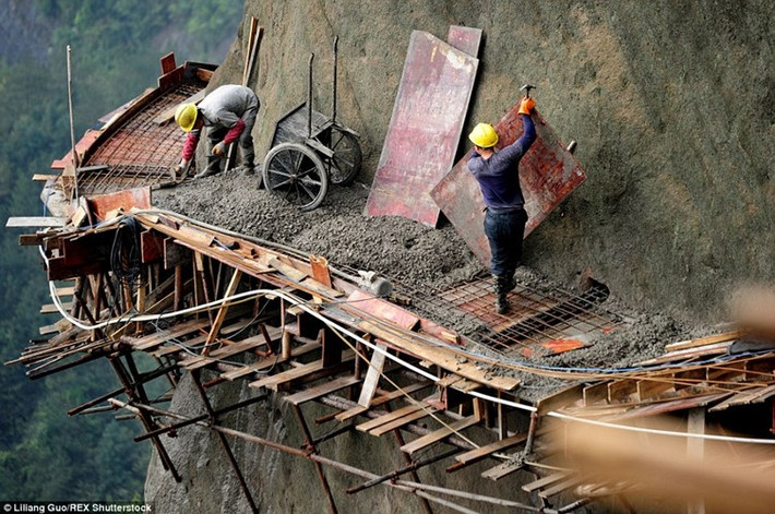 Dù không có đồ bảo hộ lao động, những người công nhân vẫn liều mình xây con đường nguy hiểm dài gần 2 km nằm trên vách núi ở Pingjiang County, tỉnh Hồ Nam, Trung Quốc.