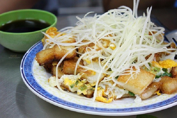 Bánh bột chiên với từng miếng bột chiên nóng hổi, bên ngoài vàng giòn, bên trong lại thơm dẻo mùi bột gạo, thêm chút bùi béo của trứng và vị sần sật, chua ngọt của đu đủ xanh cùng nước tương đường giấm ngon mê ly. Ảnh: Foody.