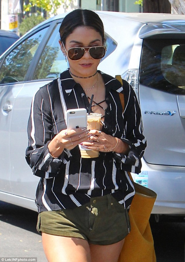 Trông Vanessa Hudgens khá vội vã khi cô vừa đi vừa cầm điện thoại liên lạc, tay còn lại thì cầm một cốc cà phê.