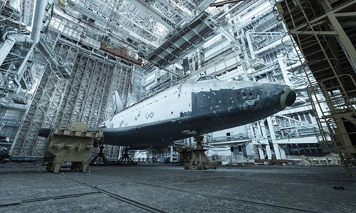 Nhiếp ảnh gia người Pháp David de Rueda ghé thăm một hangar (nhà chứa tàu bay) tại Baikonur Cosmodrome, Kazakhstan. Ông đã đến đây 3 lần trong thời gian từ năm 2015 - 2017. Tại đây, Rueda đã chụp ảnh những tàu con thoi một thời của Liên Xô. Chúng bị phủ bụi dày trong gần 30 năm qua. Trong ảnh là tàu con thoi Buran một thời của Liên Xô.