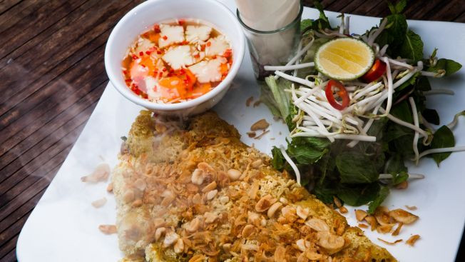 Theo truyền thống, bánh xèo được làm với nhân thịt, tôm khô, hành, giá, cuốn cùng rau thơm. Điều đặc biệt là bánh ở Don’s Bistro to gấp 3 lần bình thường và có nhân tôm tươi thơm ngọt thay cho tôm khô.