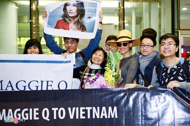Dù trời Hà Nội đang mưa phùn nhưng khoảng 20 khán giả hâm mộ Maggie Q vẫn tới sân bay Nội Bài để đón thần tượng. Họ chuẩn bị sẵn banner, poster và hoa để tặng nữ diễn viên "Naked Weapon".