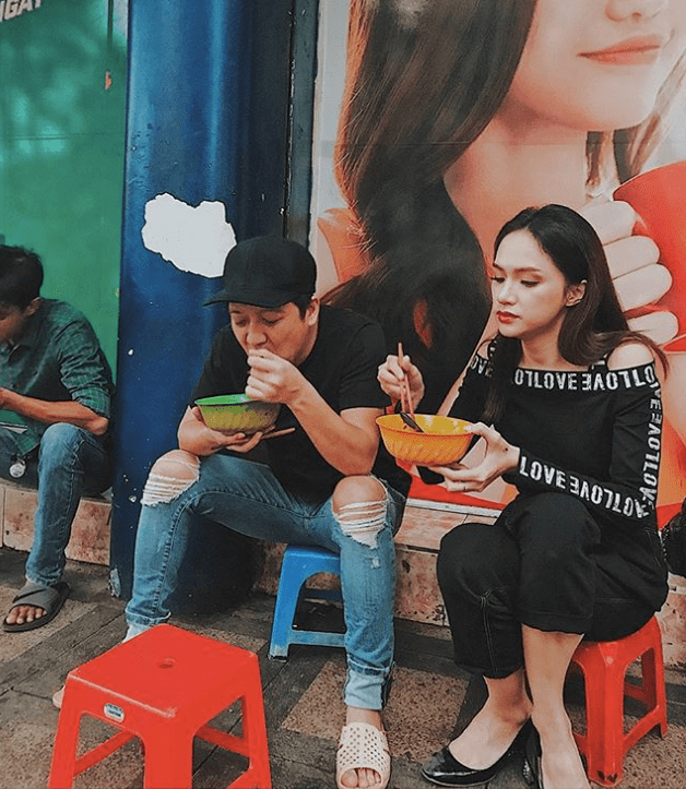 Trường Giang và Hương Giang bị bắt gặp ngồi ăn hủ tiếu vỉa hè tại TP.HCM. Cả hai ăn mặc đơn giản, đặc biệt Trường Giang còn đi đôi dép tổ ong quen thuộc, ngồi trên chiếc ghế nhỏ và cùng dùng bữa với những người xung quanh.