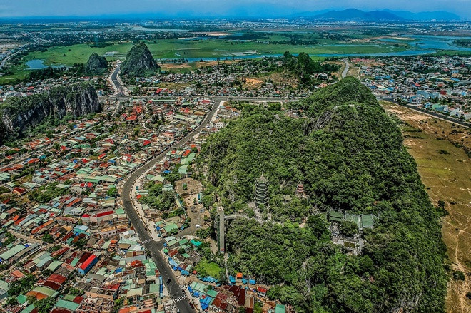 Cách trung tâm Đà Nẵng khoảng gần 10 km về phía đông nam, quần thể danh thắng Ngũ Hành Sơn nổi tiếng gồm 6 ngọn núi. Trong ảnh, tính từ phải qua, ngược chiều kim đồng hồ lần lượt là Thủy Sơn, Thổ Sơn, Kim Sơn, Hỏa Sơn - gồm Dương Hỏa Sơn cao hơn Âm Hỏa Sơn, là 2 ngọn tách rời nhau nhưng có chung một chân đá, và Mộc Sơn.