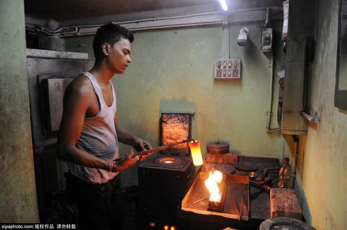 Khi hỗn vàng đồng tan chảy, người công nhân mới bắt đầu đổ vào khuôn.