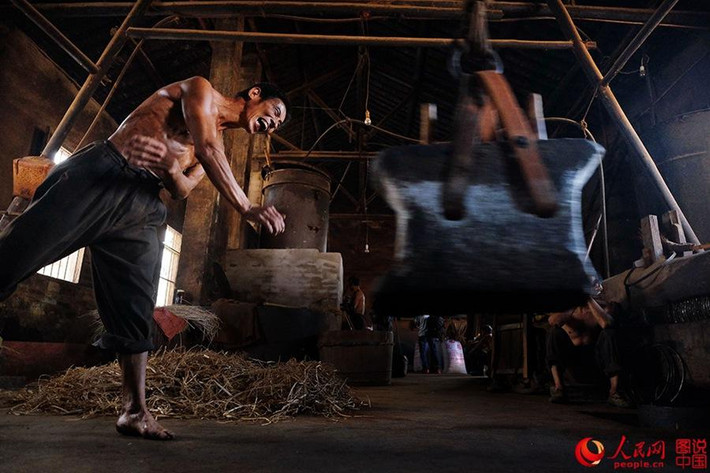 Công nhân phải dùng hết sức để đập lấy dầu hạt cải.