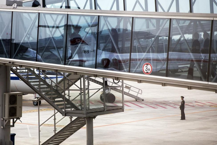Binh sĩ gác cạnh phi cơ của hãng hàng không quốc doanh Triều Tiên Air Koryo ở sân bay Bình Nhưỡng.