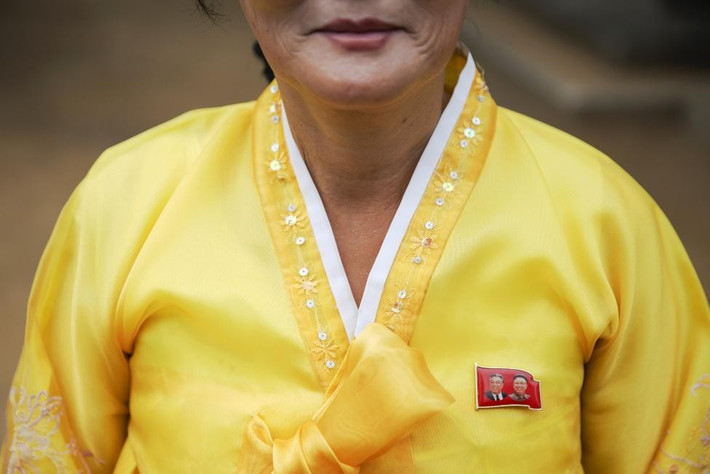 Huy hiệu in hình nhà lãnh đạo Kim Nhật Thành và Kim Jong Il trên bộ trang phục truyền thống của người phụ nữ chịu trách nhiệm hướng dẫn đoàn phóng viên nước ngoài trong chuyến tham quan ở ngoại ô Bình Nhưỡng hôm 8/10. Trong thời gian gần đây, Triều Tiên đã “cởi mở” hơn với thế giới. Sau đây là những góc ảnh lạ về cuộc sống ở Triều Tiên.