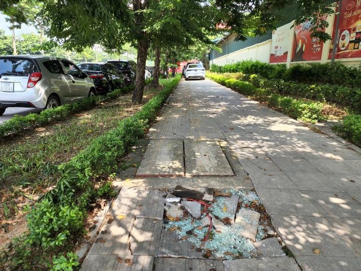 Gạch lát vỉa hè trên đường Trịnh Văn Bô cũng dần bị xuống cấp, vỡ nát bởi các xe ô tô thường xuyên dừng đỗ. >>> Mời độc giả xem thêm video Bị CSGT nhắc nhở, nữ tài xế đỗ xe chắn ngang đường thách thức: