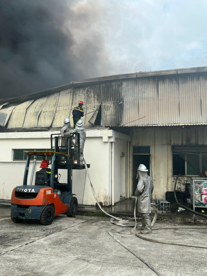 Lực lượng Cảnh sát PCCC&CNCH triển khai phá dỡ một phần tường công trình để chữa cháy.