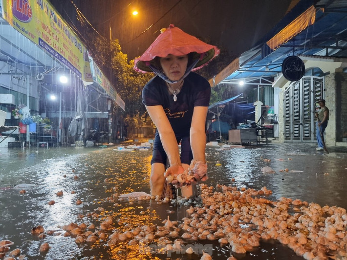 Chị Nguyễn Thị Diệu (phường Hoà Thọ Đông, quận Cẩm Lệ) thuê nhà để buôn bán rau củ quả, làm gà vịt gần chợ Hòa Cầm. Chiều tối nay thấy nước dâng, cả nhà chị hối hả dọn dẹp nhưng không thể nào dọn kịp vì nước lên nhanh. "Năm trước nước ngập cả mét, bao nhiêu tài sản bị hư sạch. Năm nay vừa vay tiền để đầu tư lại làm ăn, giờ lại chịu ngập", chị rệu rã. Trong ảnh: Những thùng tỏi không kịp kê gác đã bị ngâm nước, phải vứt bỏ.