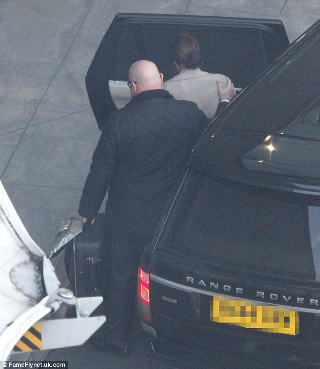 Vệ sĩ đảm bảo để paparazzi không thể chụp ảnh cận cảnh của Vic ở sân bay sau scandal của David Beckham. (Ảnh: FameFlynet)