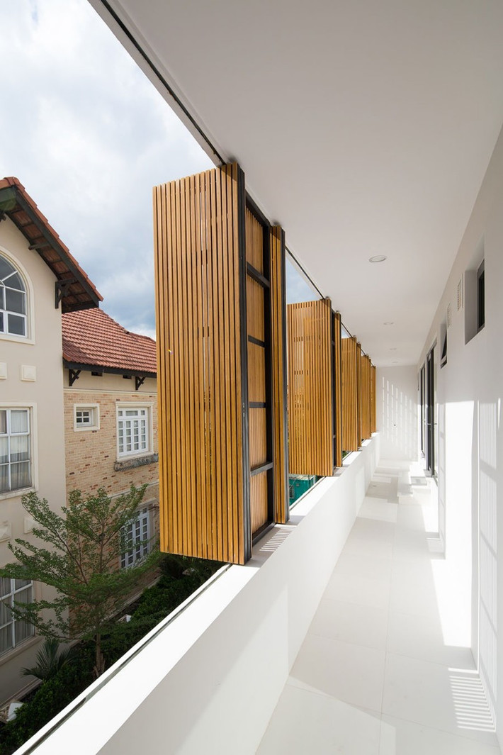 Khối tầng 2 mang chất liệu tương phản với tầng 1, ấn tượng thị giác nổi bật đến từ hệ cửa nan dọc chắn nắng cho hành lang các phòng. Việc sử dụng những chất liệu tương phản như đá, gỗ, kính có lẽ chưa mang lại hiệu quả bất ngờ.