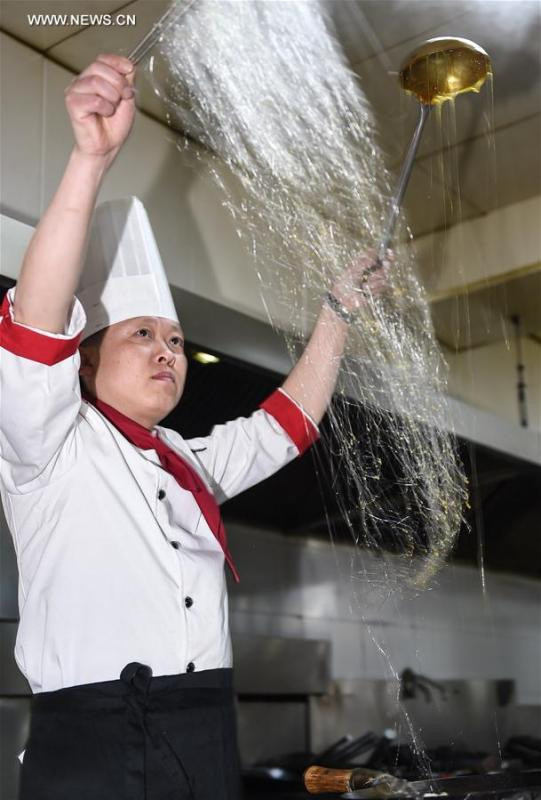 Đầu bếp Yin Chenghai khuấy sợi làm bằng đường trước khi chế biến nhân sâm nhồi vào bên trong tại nhà bếp của một nhà hàng ở Phủ Tùng, Cát Lâm, Trung Quốc.